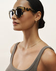 Woman wearing sunglasses with a neutral background