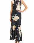 A sleeveless high-neck maxi dress with a dark navy and black base, featuring a large abstract floral print in cream, beige, and purple, modeled against a plain white background.