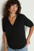 Woman wearing a black top with short sleeves against a white background