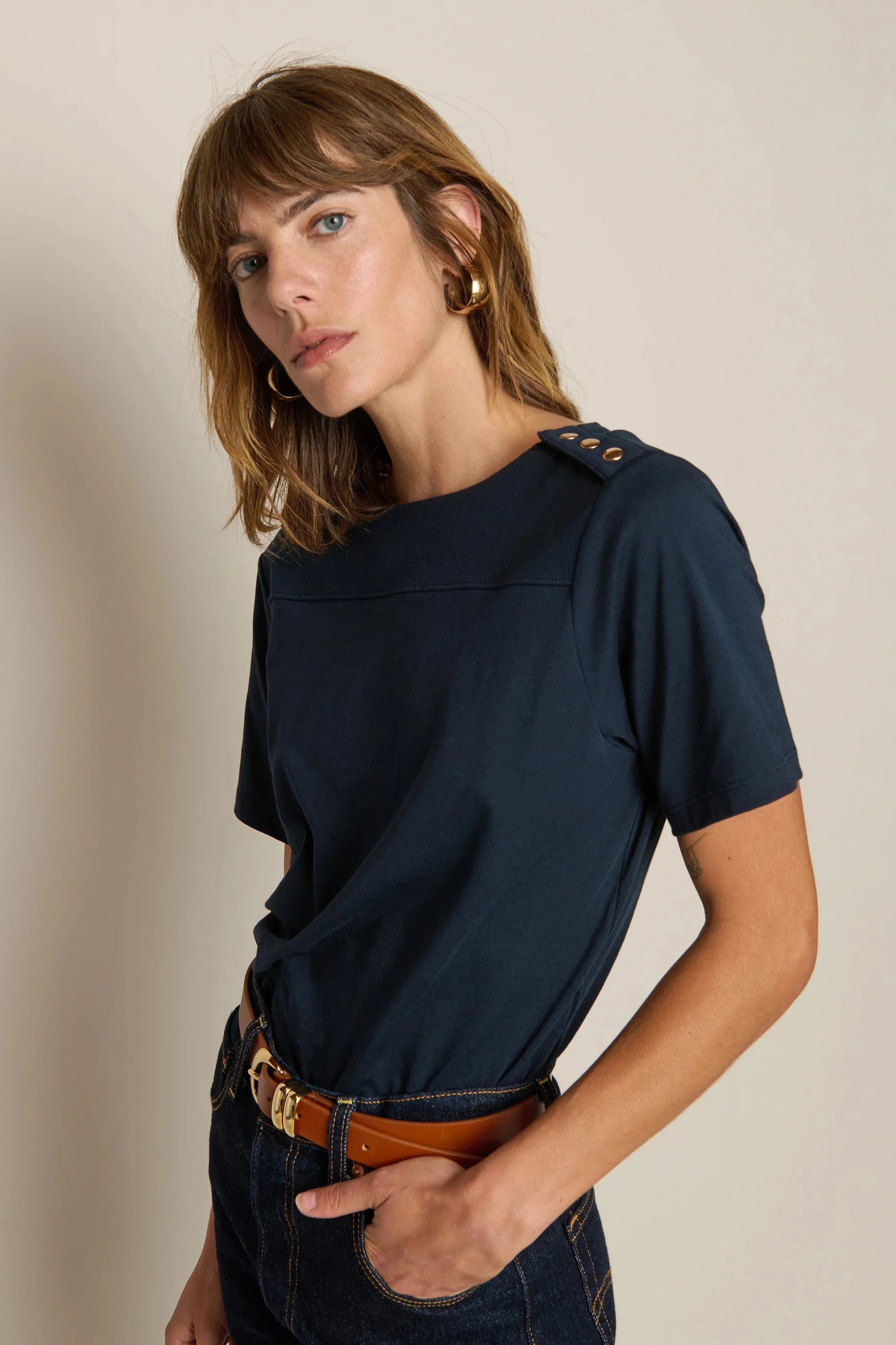 Woman wearing a navy blue t-shirt with a beige background