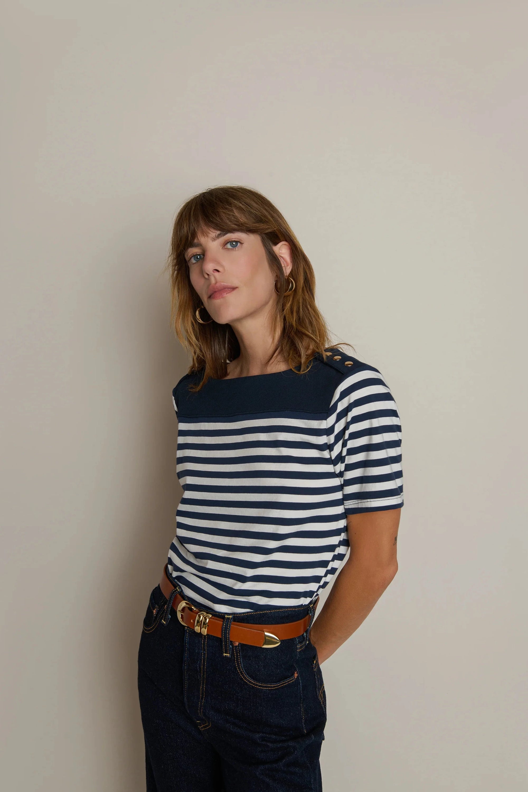 Woman wearing a navy and white striped shirt against a plain background