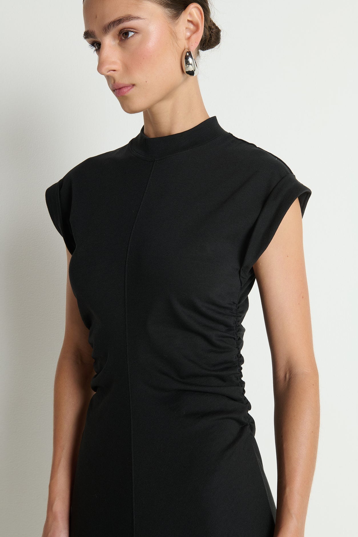 Woman wearing a black dress with a plain background