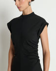 Woman wearing a black dress with a plain background