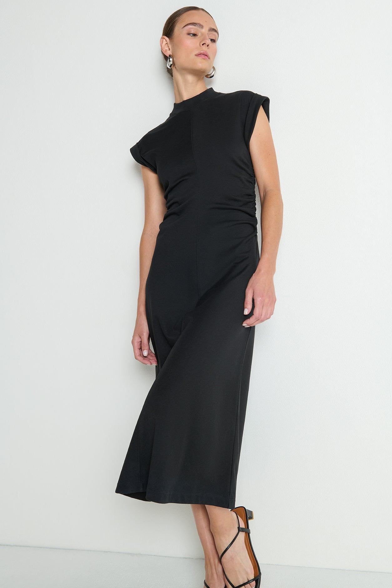 Woman wearing a black dress against a white background