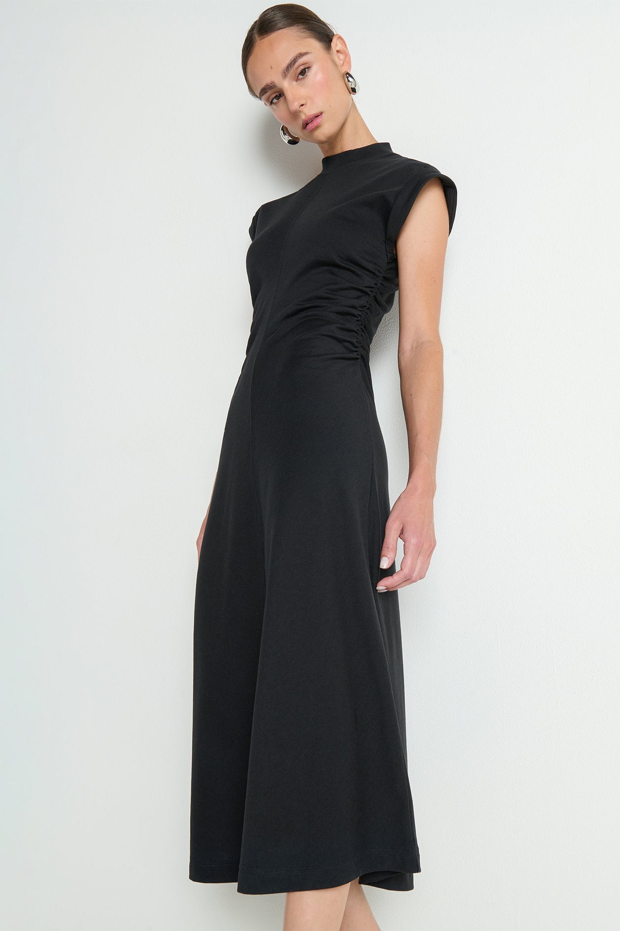 Black dress worn by a model on a white background