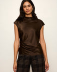 Woman wearing a brown sleeveless top and plaid pants on a white background