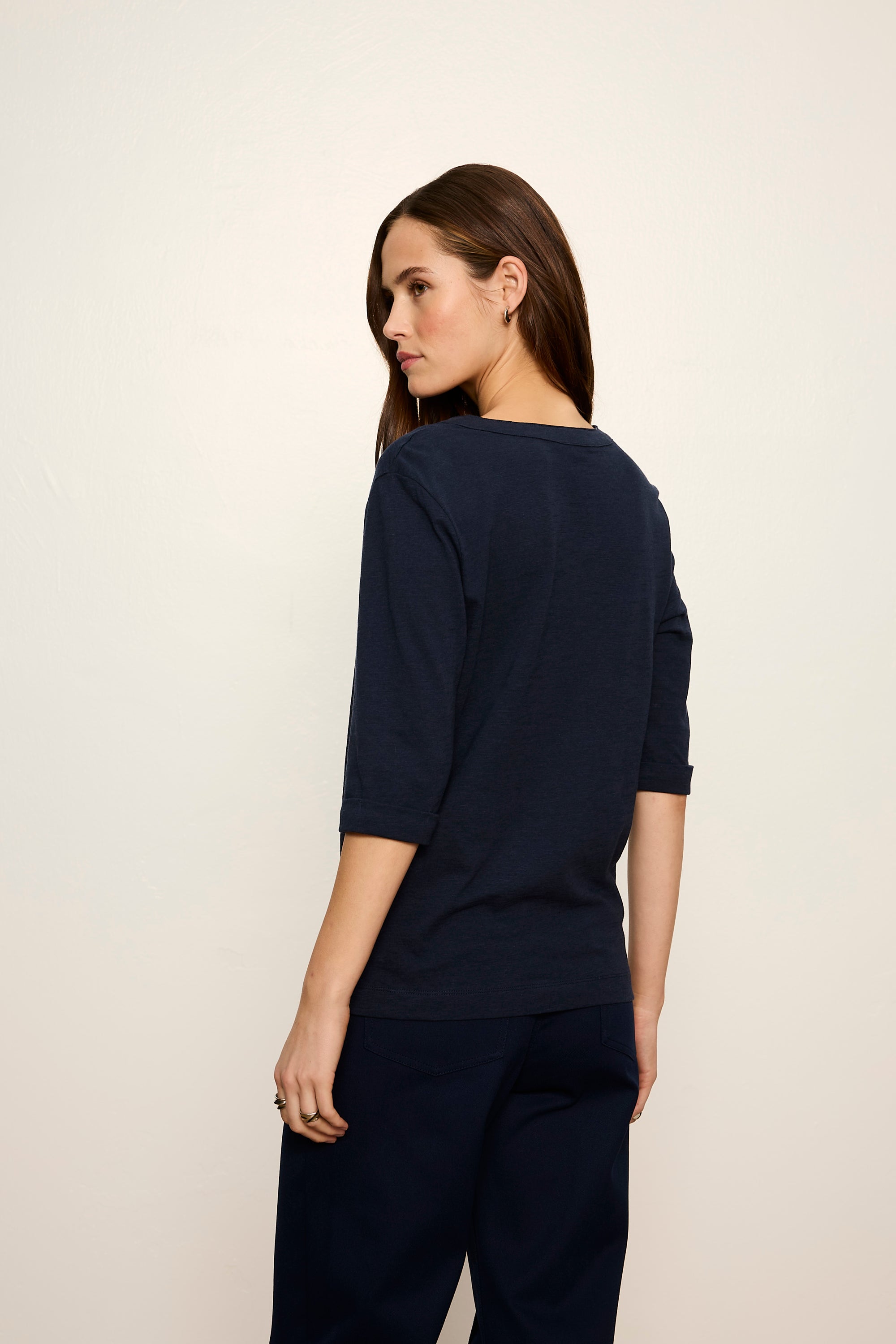 Woman wearing a navy blue outfit against a plain background