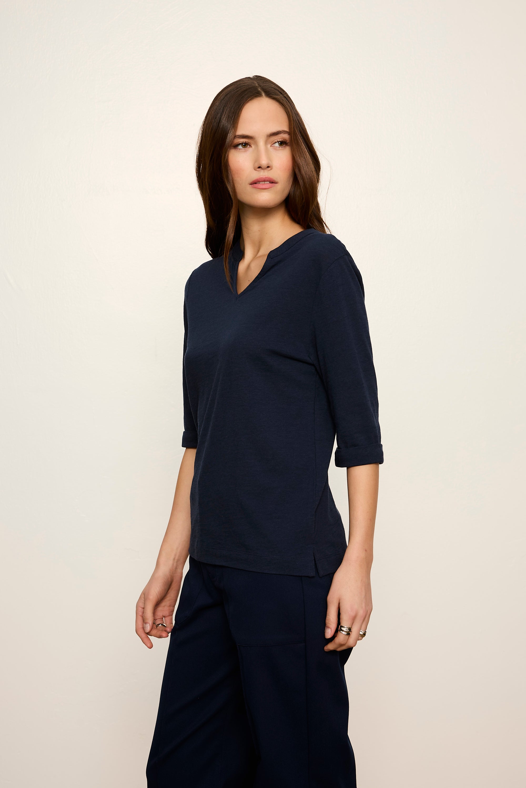 Woman wearing a navy blue outfit against a plain background