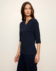 Woman wearing a navy blue outfit against a plain background