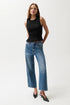 Woman wearing a black sleeveless top and blue jeans on a white background