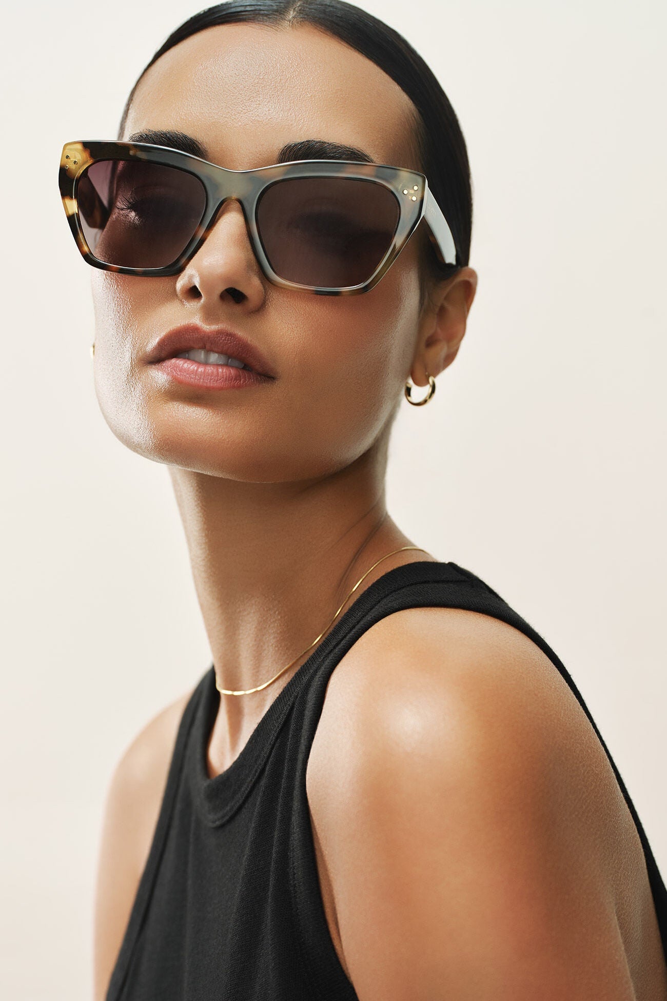 Woman wearing sunglasses with a neutral background
