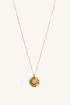 Gold necklace with a circular pendant on a white background