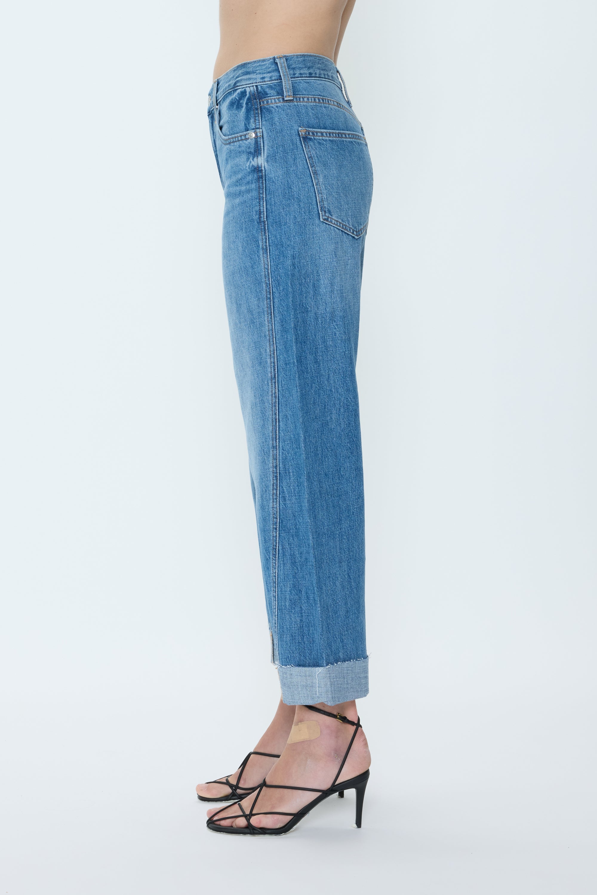 Blue jeans worn by a person on a white background