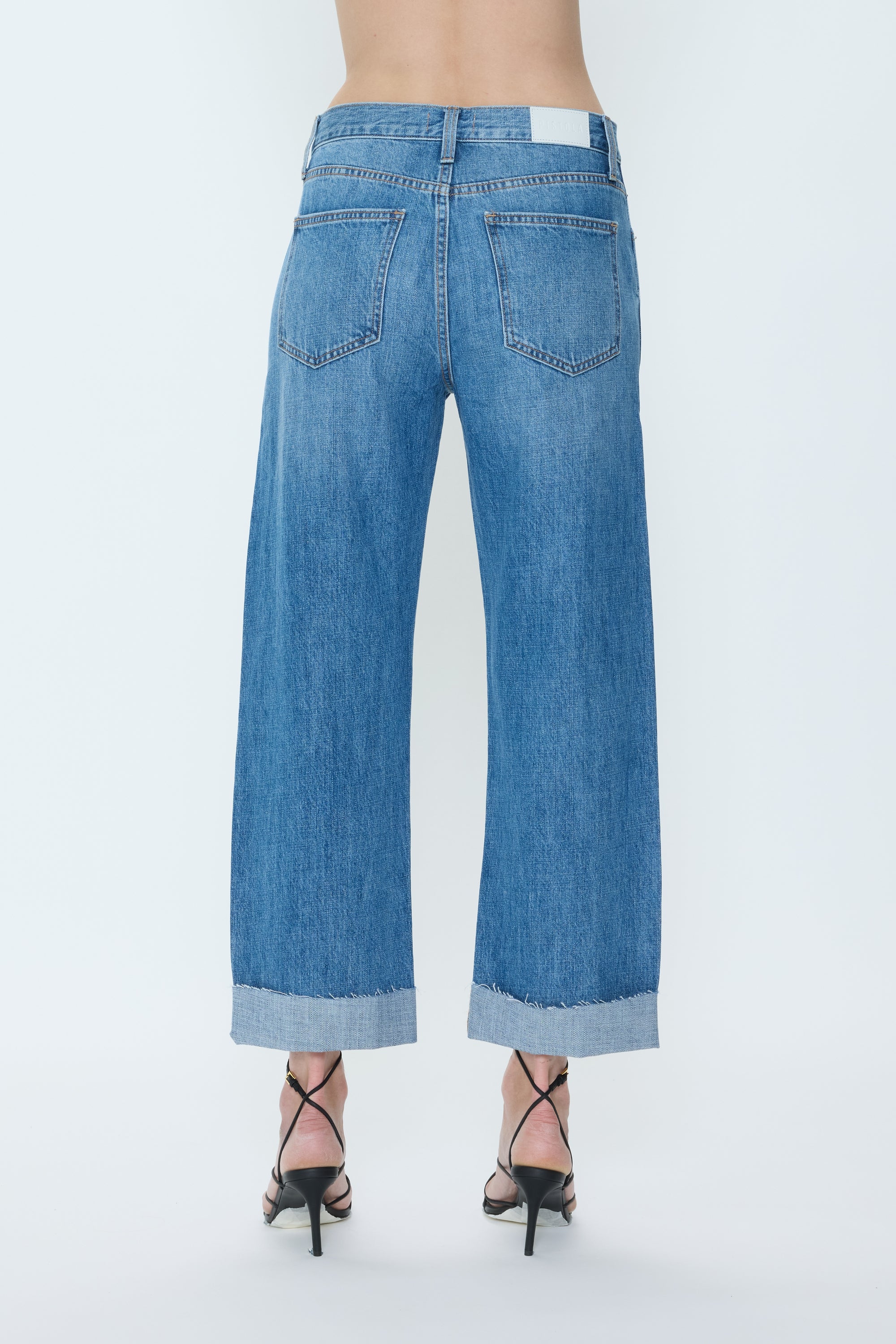 Blue jeans with a cuffed hem on a white background