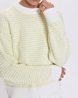 Person wearing a light green and white patterned sweater on a white background