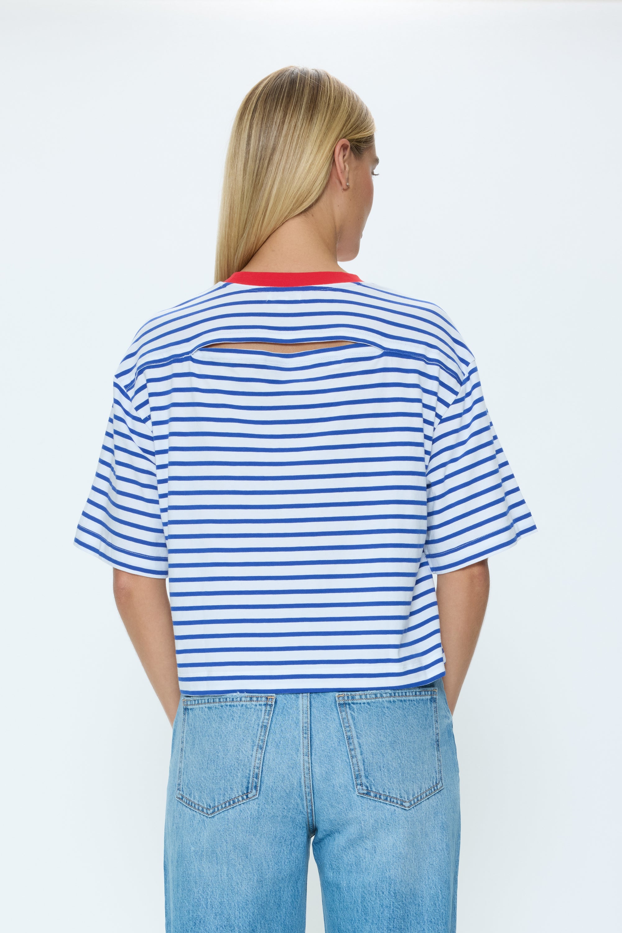 Person wearing a blue and white striped shirt with cut-out design on a white background