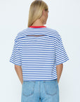 Person wearing a blue and white striped shirt with cut-out design on a white background