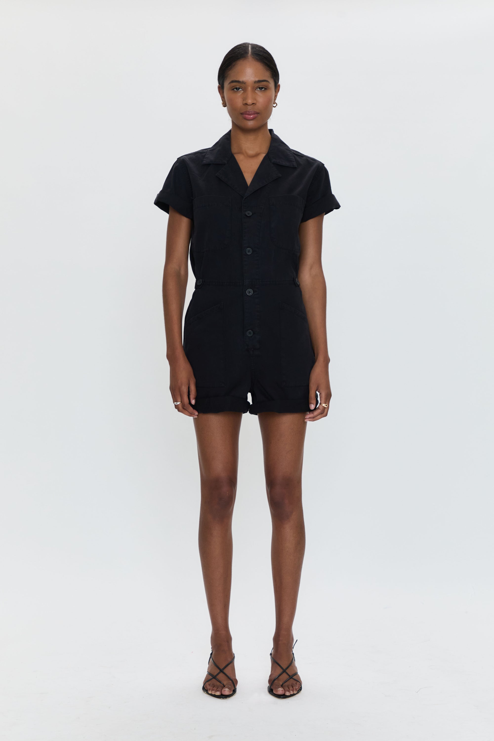 Person wearing a black romper on a white background
