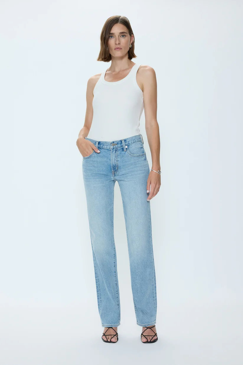 Woman wearing a white tank top and light blue jeans on a white background