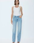Woman wearing a white tank top and light blue jeans on a white background