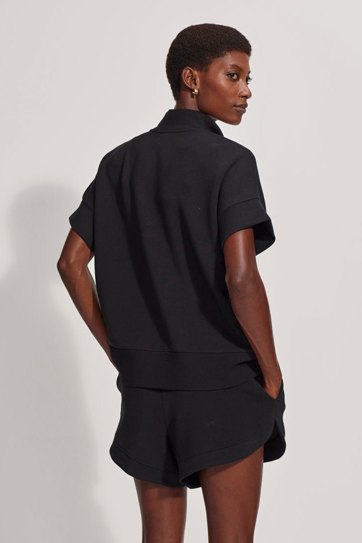 Person wearing a black outfit against a white background
