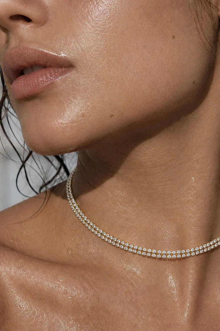 Close-up of a woman wearing a delicate necklace with a blurred background