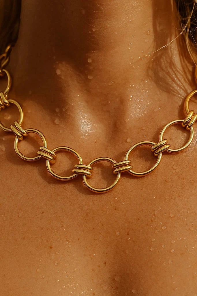 Gold chain necklace on a person's neck with a close-up view.
