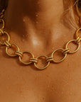 Gold chain necklace on a person's neck with a close-up view.