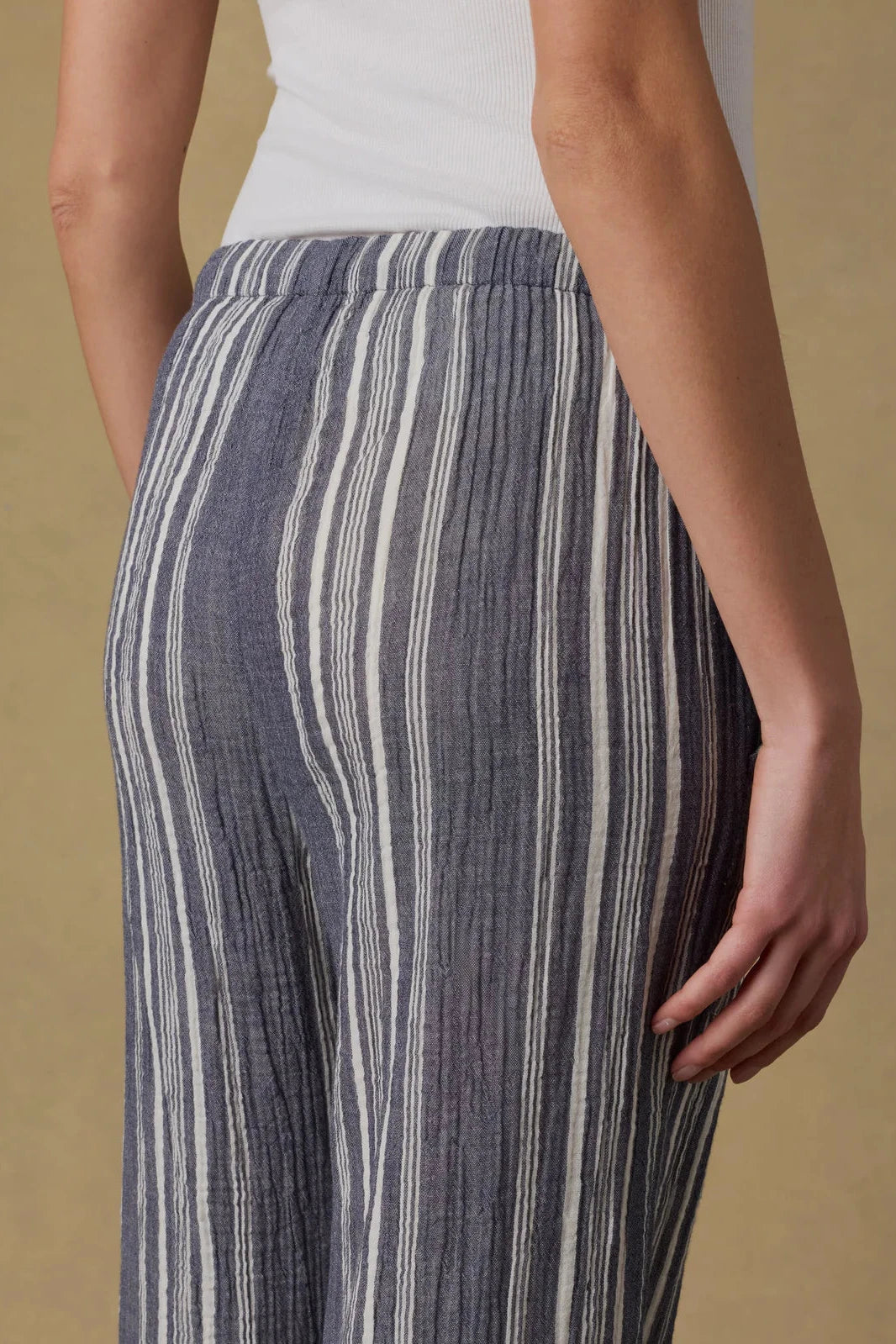 Striped pants worn by a person on a beige background