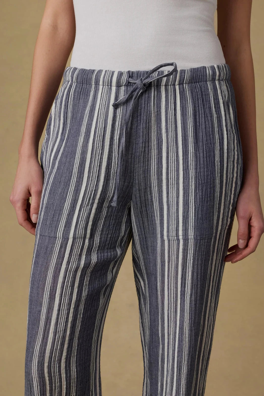 Striped pants worn by a person on a beige background