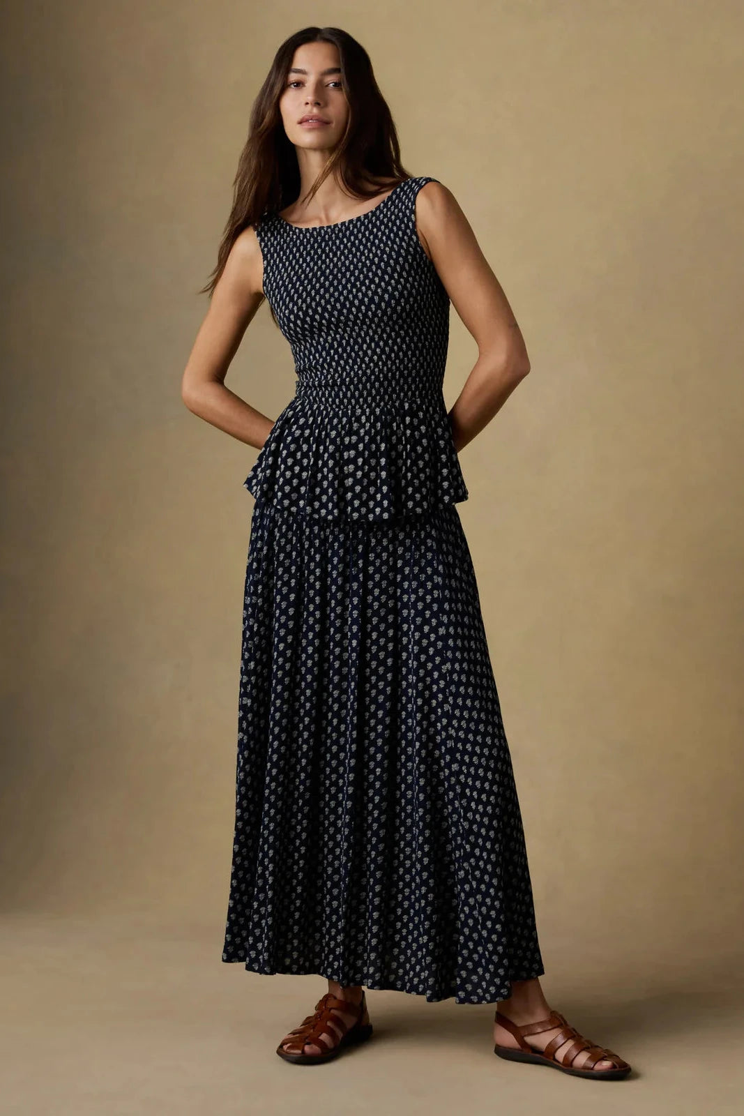 Woman wearing a black polka dot dress against a beige background