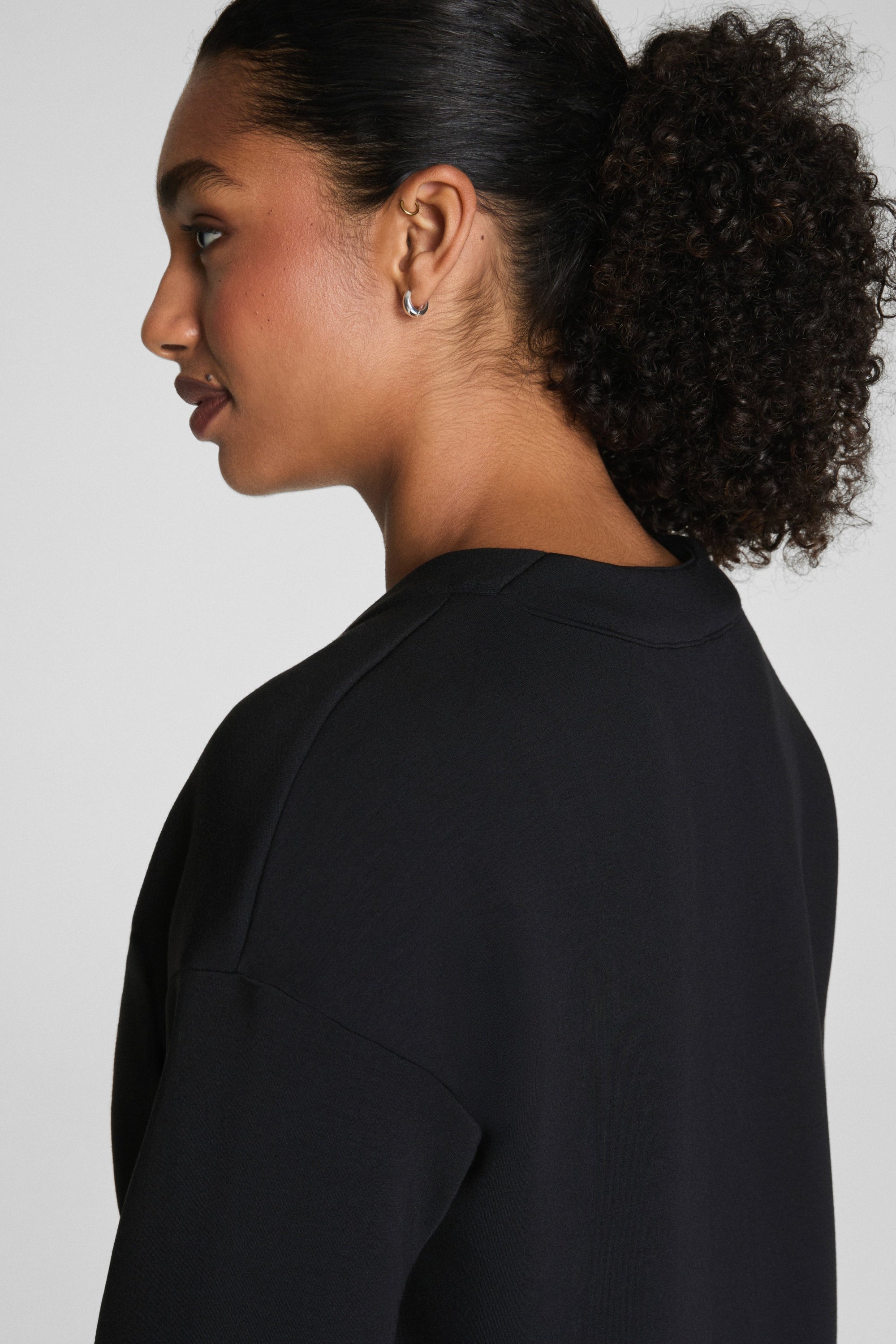 Woman wearing a black top against a plain background