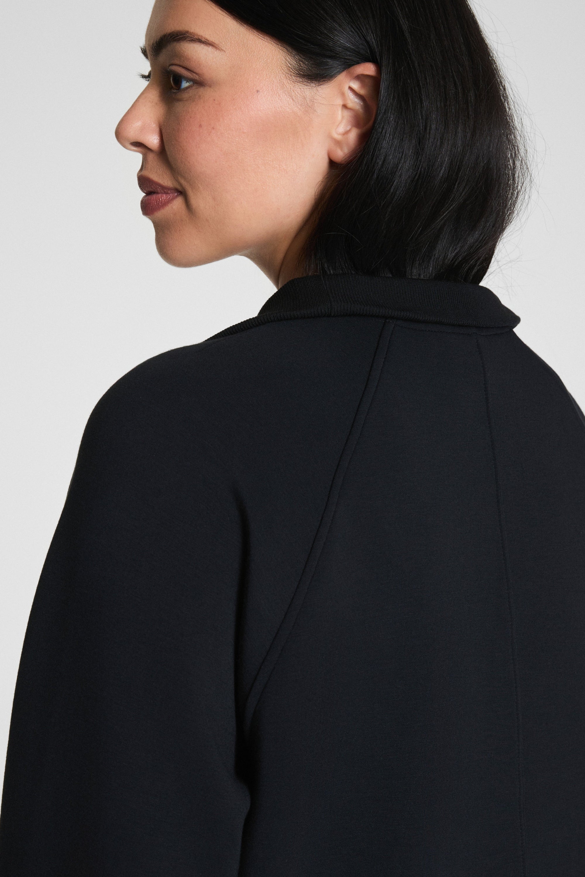 Woman wearing a black blazer against a plain background