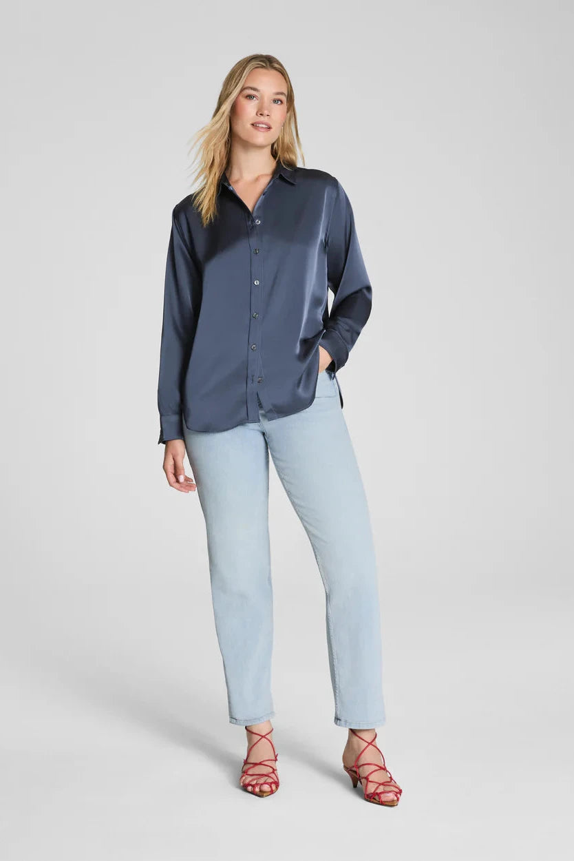 Woman wearing a navy shirt and light blue jeans on a white background