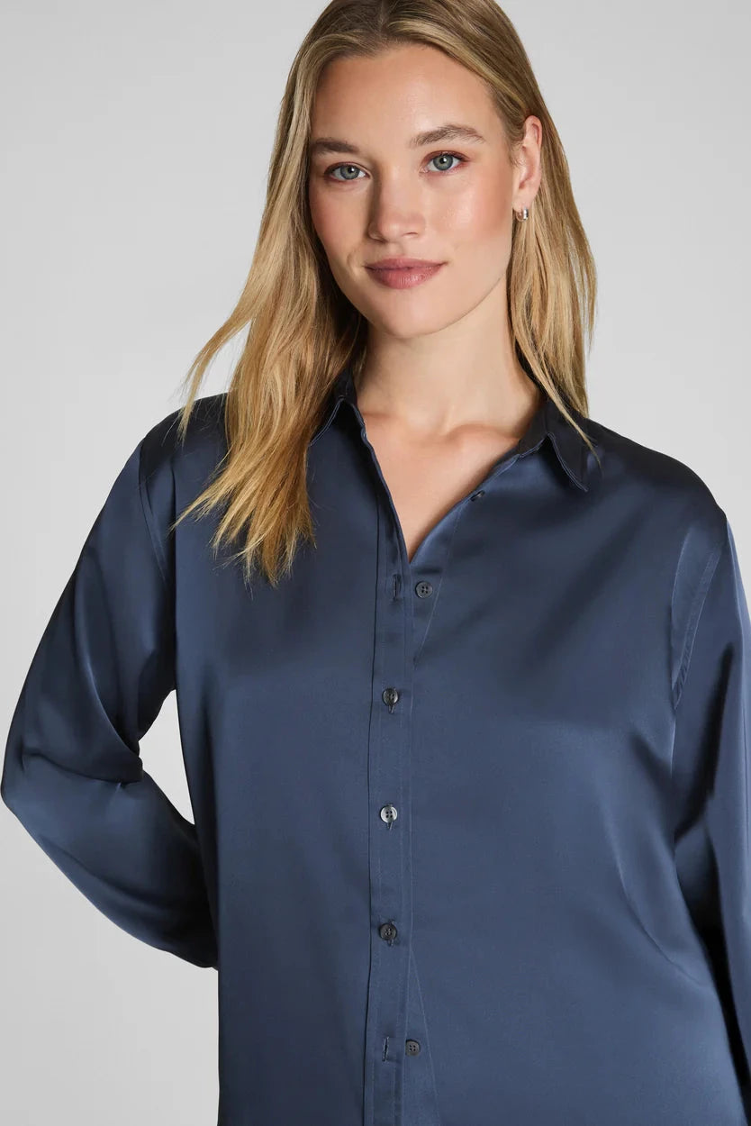 Woman wearing a navy blue shirt against a plain background