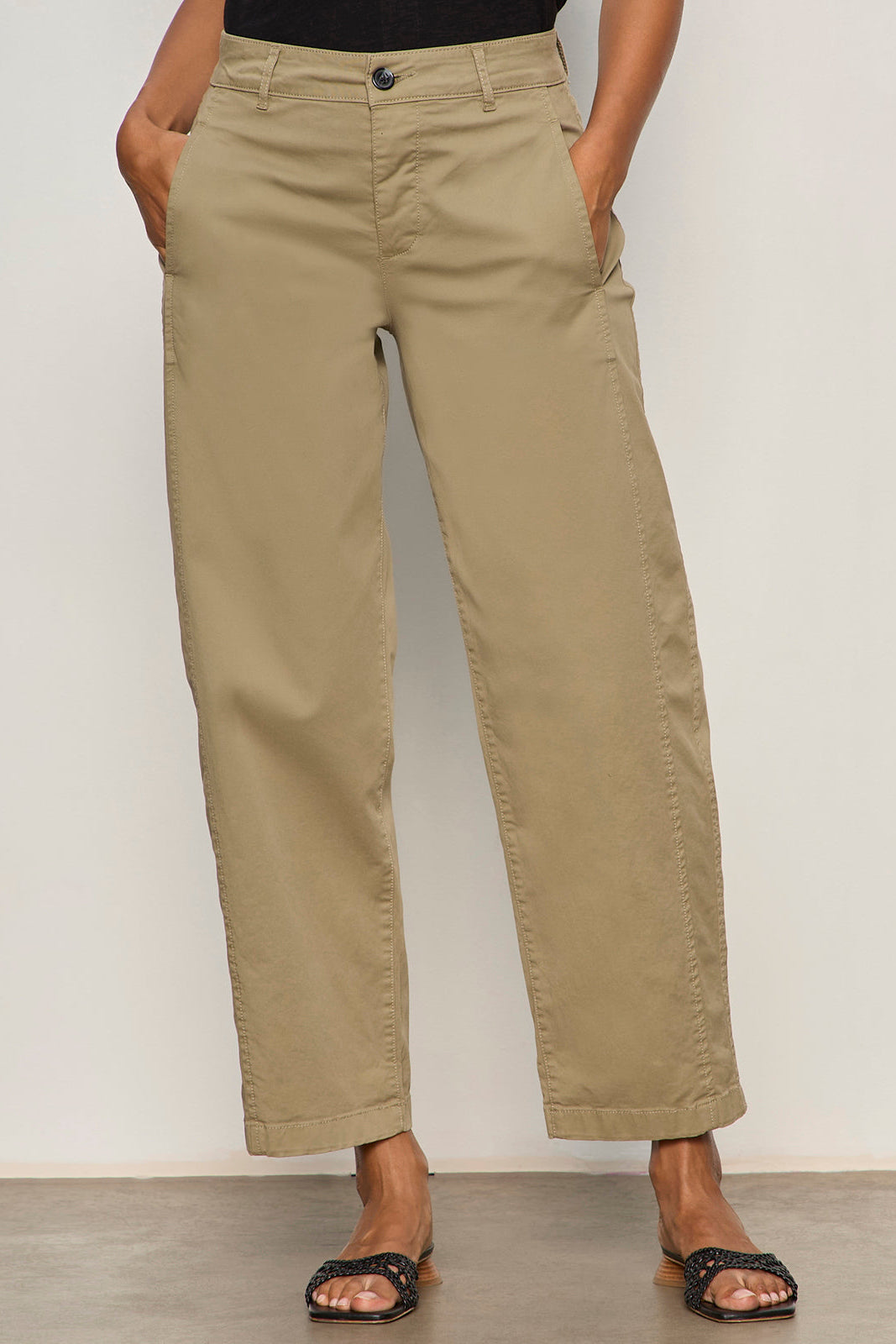 Person wearing beige pants against a plain background