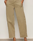 Person wearing beige pants against a plain background