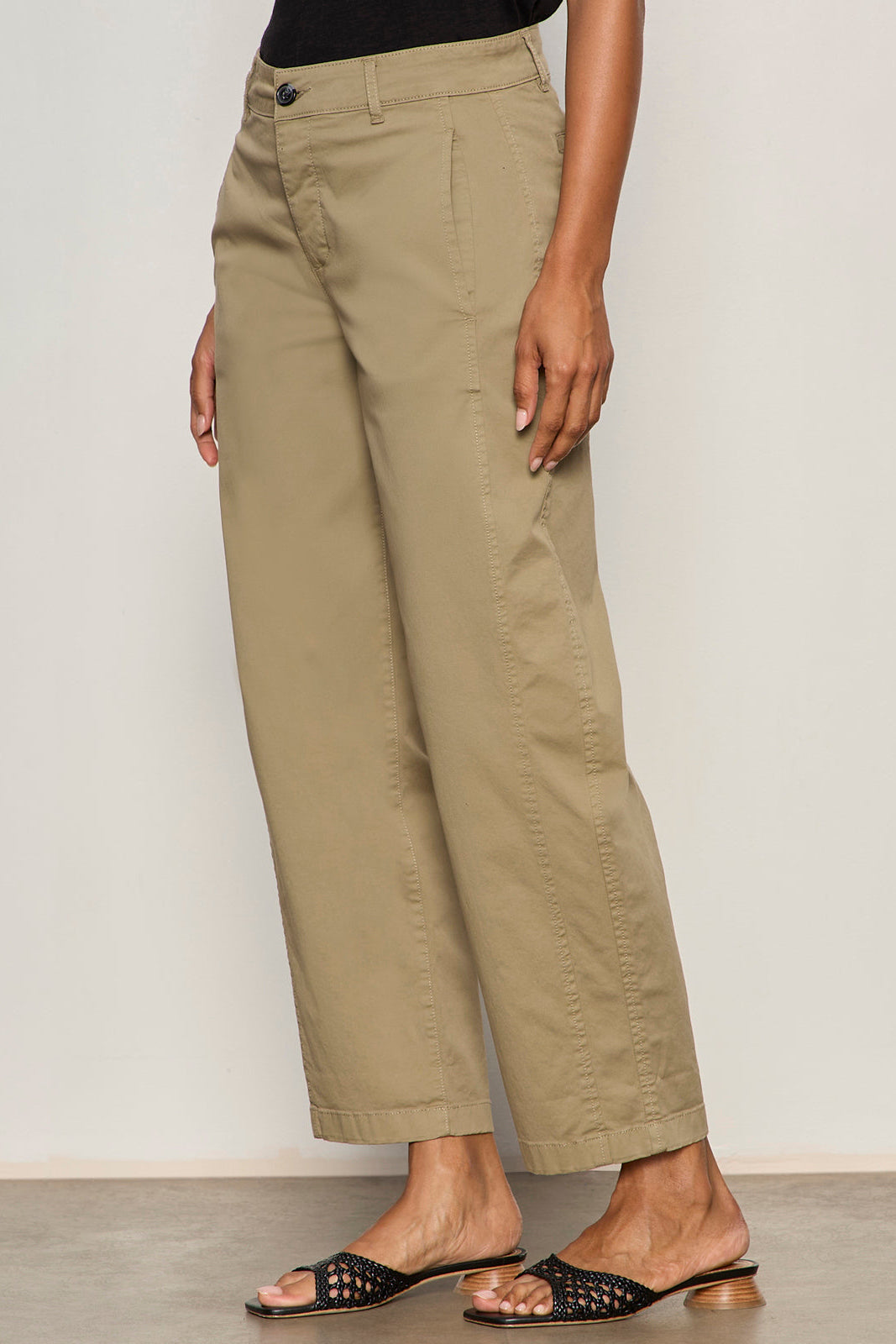 Person wearing beige pants against a plain background