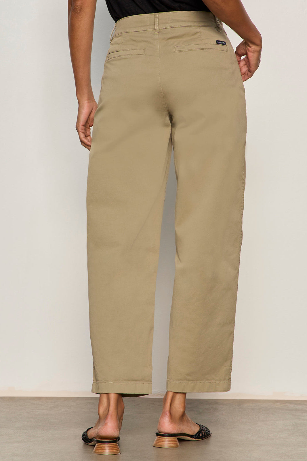 Person wearing beige pants against a plain background