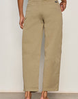 Person wearing beige pants against a plain background