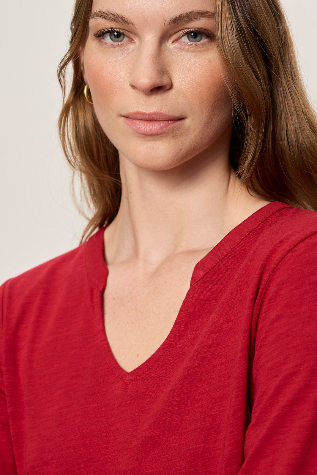 Woman wearing a red shirt against a plain background