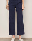 Person wearing navy blue pants with a plain background