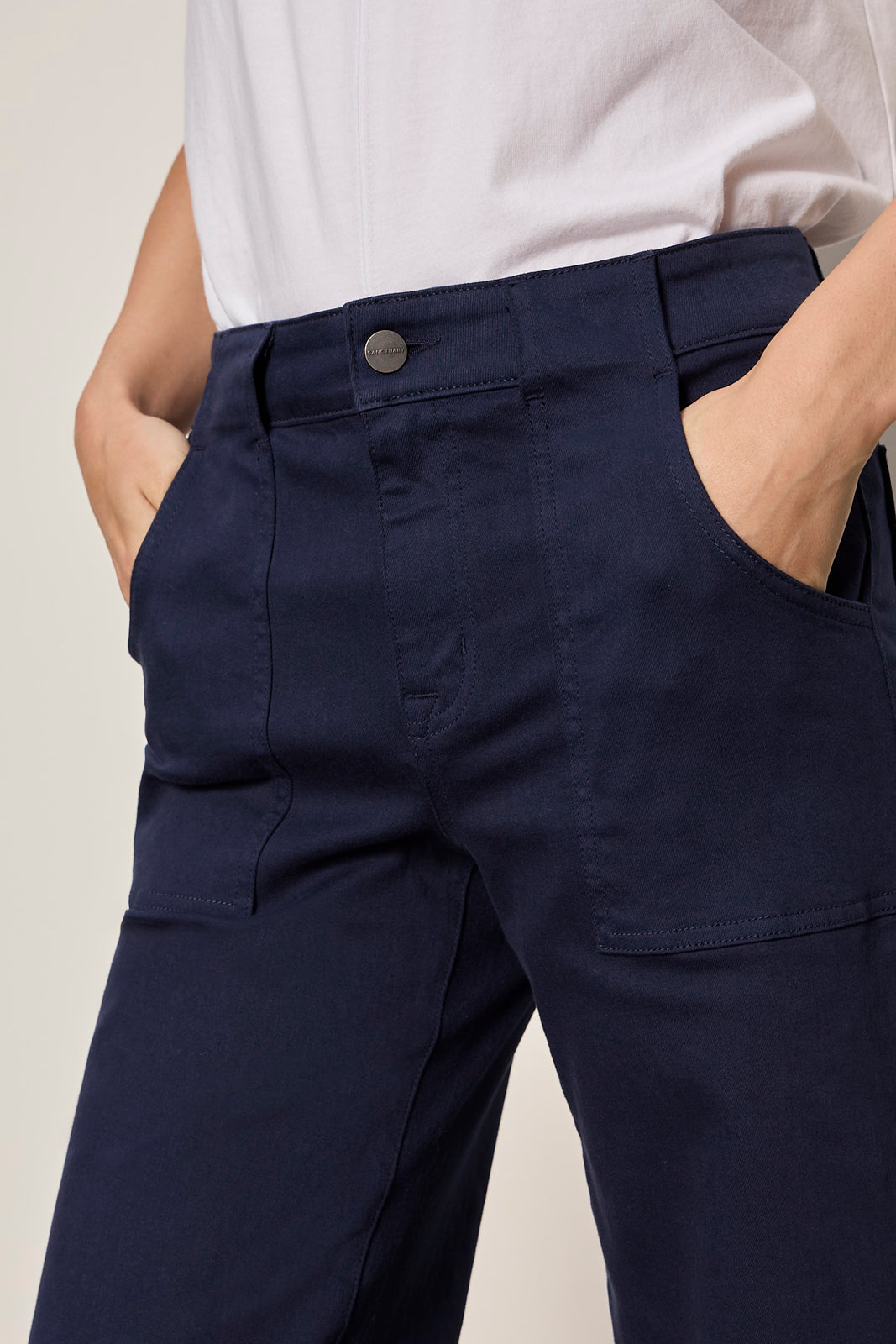 Navy pants worn by a person against a neutral background