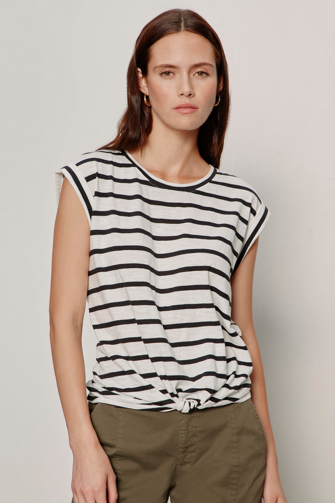 Woman wearing a black and white striped t-shirt against a plain background