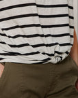 Person wearing a black and white striped shirt and green pants.
