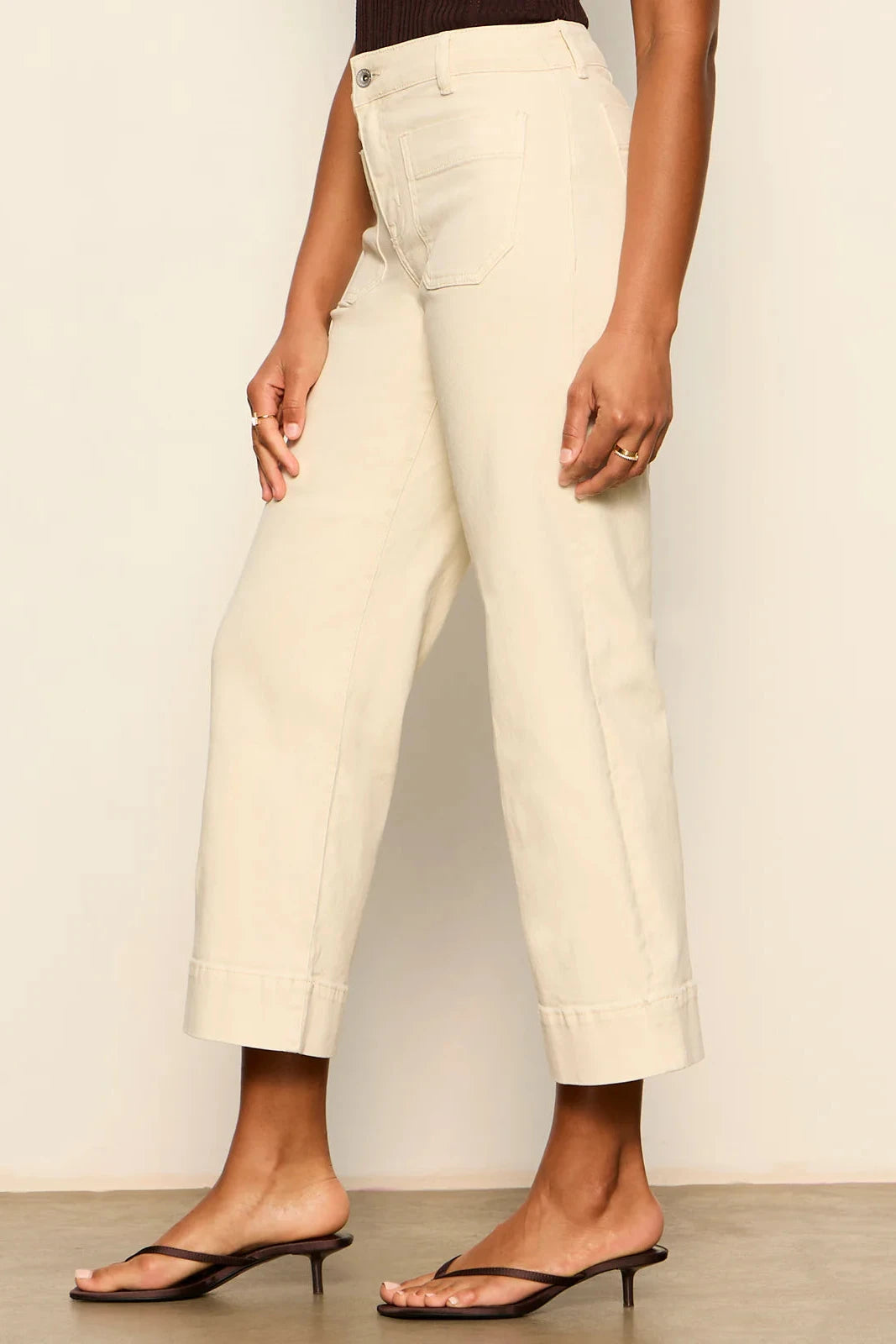 Person wearing white pants against a plain background