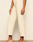 Person wearing white pants against a plain background