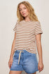 Woman wearing a striped shirt and denim shorts against a plain background