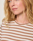 Woman wearing a striped shirt with a neutral background