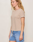 Woman wearing a striped shirt and denim shorts against a plain background